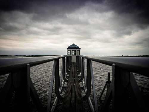 small lighthouse at the lauwersmeer during a rainstorm