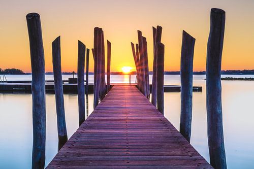 Pier oder Steg am Strand bei Sonnenaufgang.