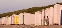 Kinderen staan eenzaam voor een gesloten strandcabine met een afbeelding van Nijntje aan het strand,