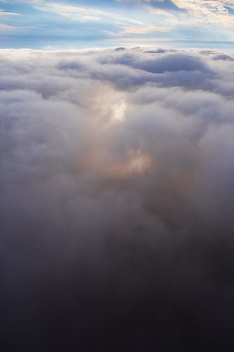 Flying above the glowing clouds, a symbol of the flight of a dream, a photo from a paraglider.
