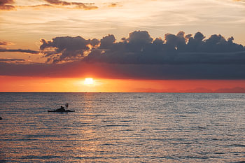 Lever de soleil romantique avec un petit bateau de pêche