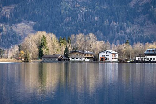 Reflets de chalets au bord d'un lac de montagne.