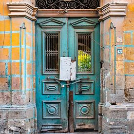 Oude deur in zeegroen met goudgeel gezien in Noord Cyprus van Marianne van der Zee