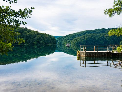 Nationalpark Kroatien. Spiegelung im Wasser mit Boot und Bergen im Hintergrund