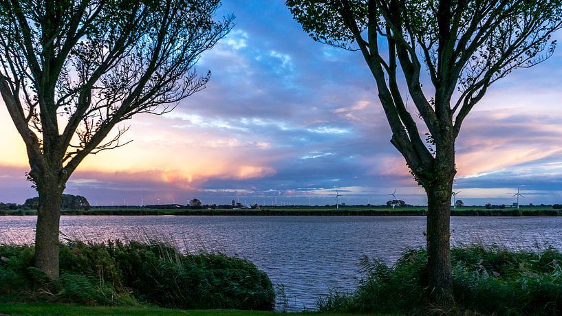 Landschap | Bijzonder mooi belichte wolkenlucht boven het water van Rob Baken