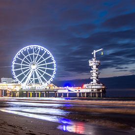 Donker silhouette tegen de verlichte pier van Scheveningen van Mike Pennings