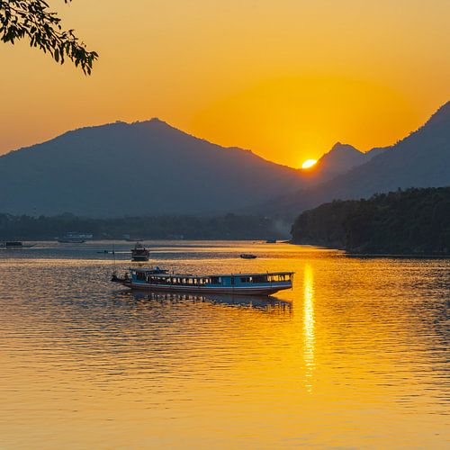 Langzame boot bij zonsondergang op de Mekong bij Luang Prabang in Laos