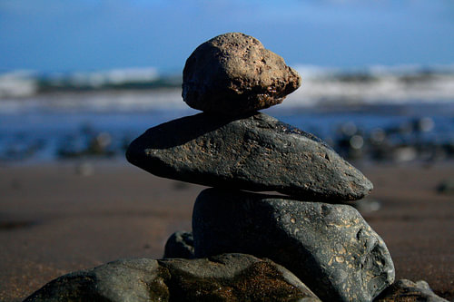 stacked stones with the beauty of the sea behind it.