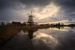 Molen De Rat in IJlst vanaf de steiger – winterse reflectie aan het water onder een dramatische lucht