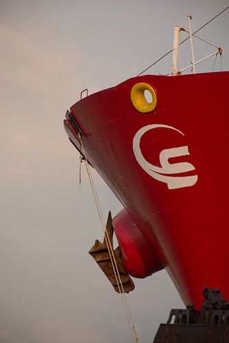De rode boeg van een zeeschip in de haven