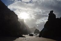 Eerste zonnestralen door de bergen op het strand.