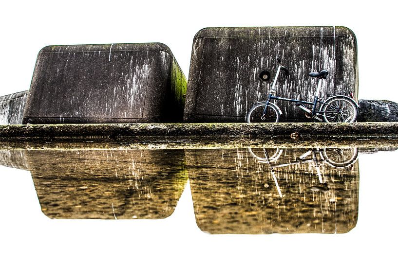 Betonblokken en fiets weerspiegeld in een plas op de Zuidpier by Harrie Muis