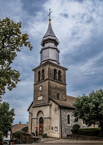 Woman with a red umbrella, beneath the church tower, Yvoire