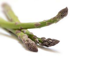 groene asperges, drie speren in een close-up shot, geïsoleerd met schaduwen op een witte achtergrond van Maren Winter