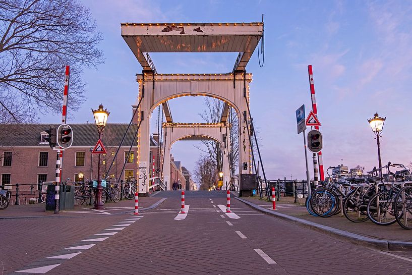 Medieval drawbridge on the Amstel River in Amsterdam at sunset by Eye on You