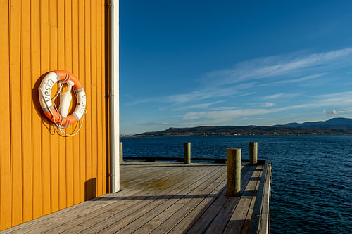 A lifebuoy that contrasts nicely with the blue waters of the Lofoten Islands in Norway