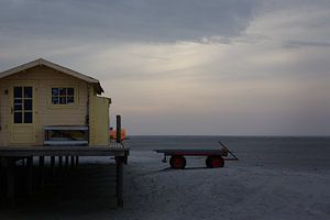 Geel strandhuisje in de namiddagzon van Ebelien