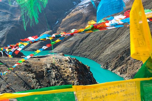 Look through the prayer flags to the river, Himalayas