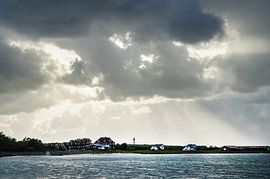coast with lighthouse and dramatic cloudy sky by Alexander Baumann