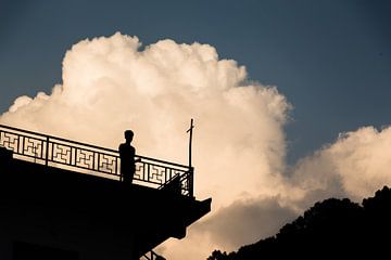 Silhouet voor grote wolk bij laagstaande zon van Joep van de Zandt