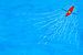Rode kano in blauwe zee met witte golfjes van Susan Hol