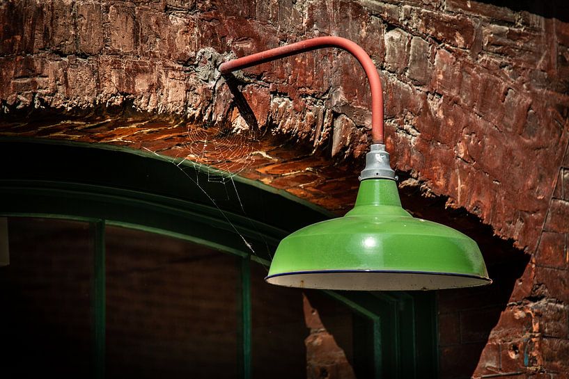 Green metal lamp on a stone wall. by Jan van Dasler