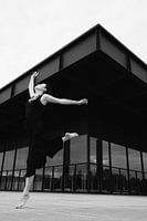 Saut dans la lumière : énergie dansante devant une façade géométrique