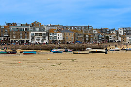 Eb in de haven van St Ives met boten op het zandstrand in Cornwall