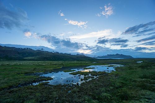 IJsland - Besneeuwde bergen, gletsjer en weerspiegelend landschap in de schemering