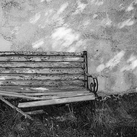 Banc de jardin usé par le temps devant un vieux mur de maison sur Fartifos