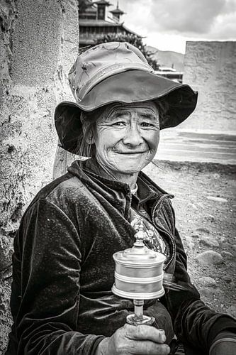 Tibetan woman with spinning prayer wheel, portrait