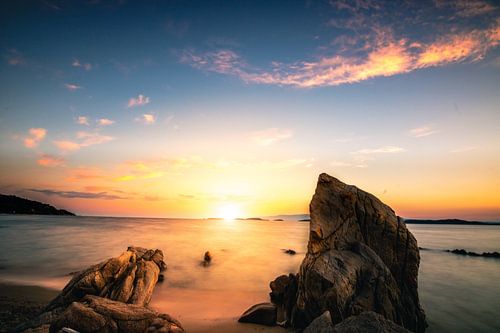 Zonsondergang aan de kust van Griekenland met strand en stenen