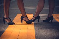 Two elegant women in high heels black shoes and sexy fishnet stockings