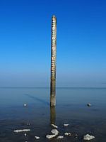 Measuring post on a windless day in the Wadden Sea near Wierum
