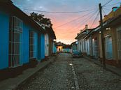 Oranje zonsopkomst in een straat in Trinidad de Cuba met oldtimer van Michiel Dros thumbnail
