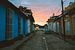 Oranje zonsopkomst in een straat in Trinidad de Cuba met oldtimer van Michiel Dros