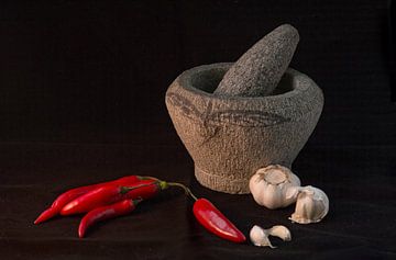 Still life of a      Still life of an Indonesian mortar with red peppers and garlic against a black by Birgitte Bergman