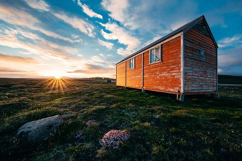Wooden house in the sun in deserted landscape