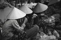 Drie vrouwen met een banaan op de markt, Hoi An, Vietnam