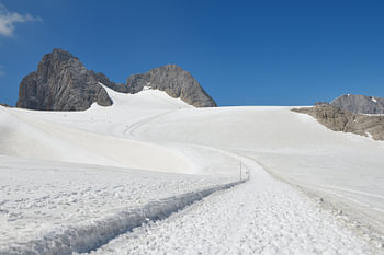 Paysage glaciaire du Dachstein avec un sentier de montagne enneigé. Styrie, Autriche