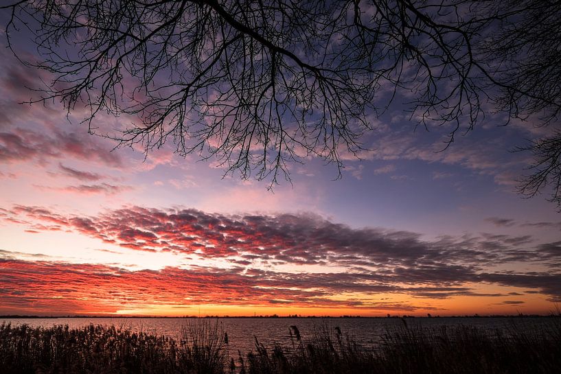 Setting sun above a lake by Henk Vrieselaar