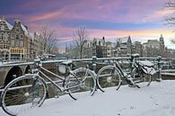 Besneeuwd Amsterdam in de winter bij zonsondergang von Eye on You Miniaturansicht