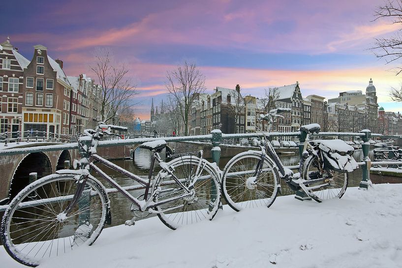 Besneeuwd Amsterdam in de winter bij zonsondergang von Eye on You