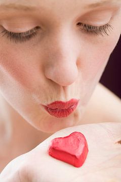 SF00933955 Frau küsst ein rotes Schokoladenherz von BeeldigBeeld Food & Lifestyle