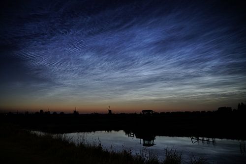 Silhouettes met lichtende nachtwolken