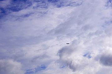 Vliegtuig in de bewolkte lucht