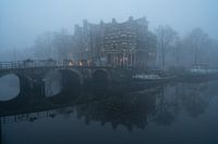 Huizen aan een kanaal in de mist