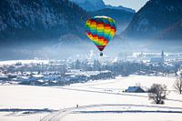 Heißluftballons schmücken den Himmel über dem verschneiten Inzell in Deutschland