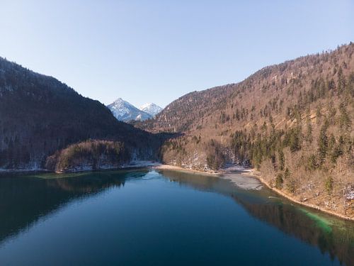 Aerial view of Alpsee with mountains and forests