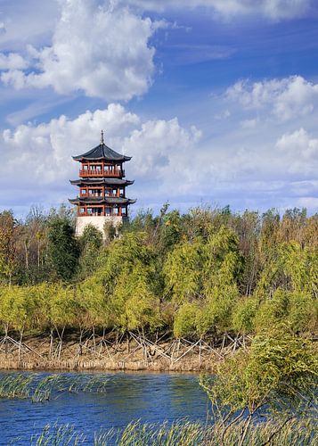 traditional pagoda, trees, blue sky and dramatic clouds